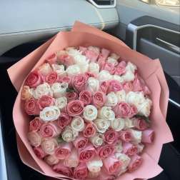 Large bouquet of pink and white roses wrapped in pink paper