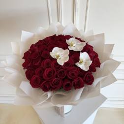 Bouquet of red roses with three white orchids wrapped in white paper