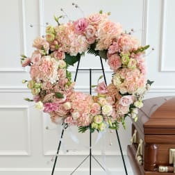 Pastel floral wreath on a stand with pink and cream blooms