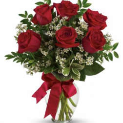 Bouquet of red roses with white filler in a clear glass vase