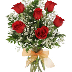 Red roses with white baby's breath in a glass vase with a gold bow