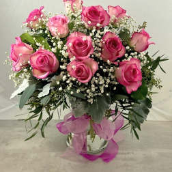 Pink roses arranged in a glass vase with baby's breath