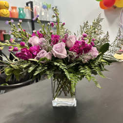 Pink and lavender roses in a clear glass vase