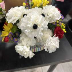 White carnations with colorful daisies in a striped container