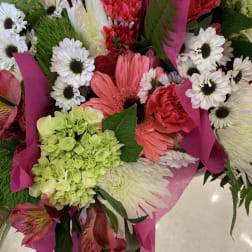 Mixed bouquet with pink gerbera daisies, white daisies, and green hydrangea