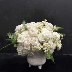 White floral arrangement in a ribbed ceramic vase