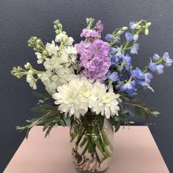 Bouquet of white, pink, and blue flowers in a glass vase