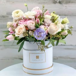 Pastel bouquet of roses and tulips in a white hatbox