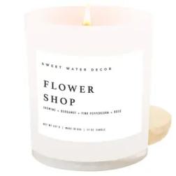 White candle in a glass jar labeled Flower Shop
