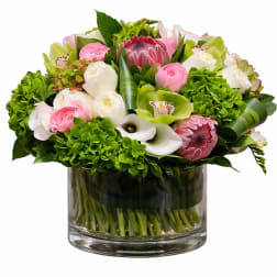Pink and white flowers arranged in a clear glass vase