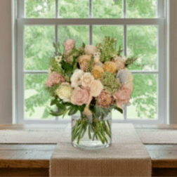 Pastel rose bouquet in a clear glass vase on a table
