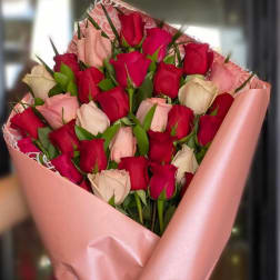 Bouquet of red and blush roses wrapped in pink paper