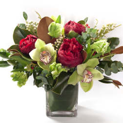 Bouquet of red and green flowers in a clear square vase