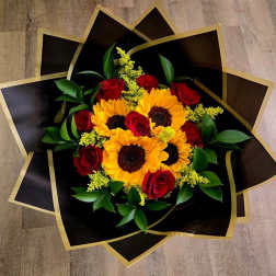 Bouquet of red roses and yellow sunflowers in black and gold wrap