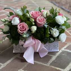 Pink and white roses in a decorative box with a pink ribbon