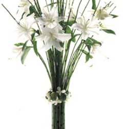 White lilies in a tall glass vase with greenery