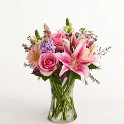 Pink roses and lilies in a clear glass vase
