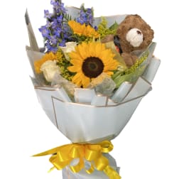 Bouquet of sunflowers, blue flowers, white roses, and a teddy bear