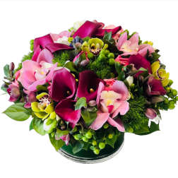 Bouquet of pink calla lilies and orchids in a glass vase