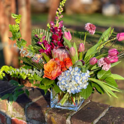 Colorful mixed bouquet in a clear square vase