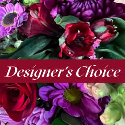 Mixed bouquet of purple and red flowers with a Designer's Choice banner