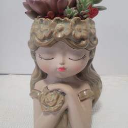 Ceramic girl planter with succulent arrangement on top
