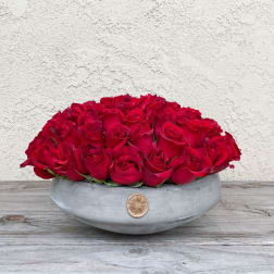 Low arrangement of red roses in a gray bowl vase