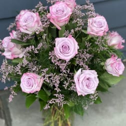 Bouquet of pale pink roses with small filler flowers in a glass vase