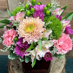 Pink and purple mixed flower arrangement in a dark vase