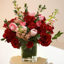 Red and pink roses arranged in a clear glass vase