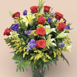 Bouquet of red roses and lilies in a clear glass vase