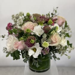 Mixed pink and white bouquet in a green glass vase