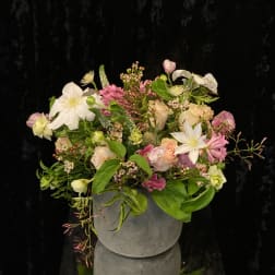 Mixed pink and white floral arrangement in a gray vase