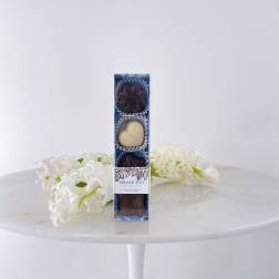Box of chocolates with white flowers on a table