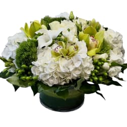White and green floral arrangement in a low glass vase
