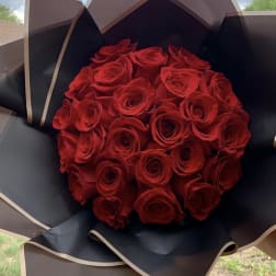 Bouquet of red roses wrapped in black paper