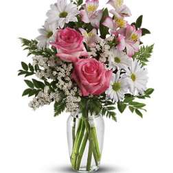 Pink roses and white daisies in a clear glass vase