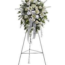 White floral standing spray on an easel with ribbon