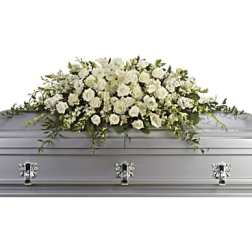 White floral casket spray on a silver casket
