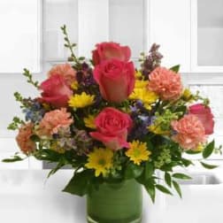 Mixed bouquet of pink roses and yellow daisies in a green vase