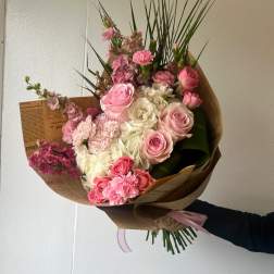 Pink and white mixed bouquet wrapped in brown paper