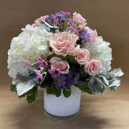 Pink roses and white hydrangeas in a white vase