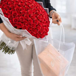 Large bouquet of red roses wrapped in white paper