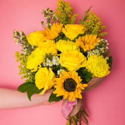 Yellow bouquet with roses, sunflowers, and mums tied with a striped ribbon