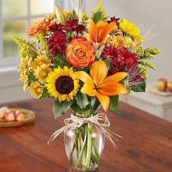 Bouquet of orange, yellow, and red flowers in a glass vase