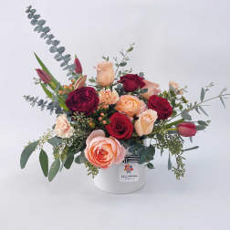 Mixed rose bouquet in a white hat box with eucalyptus accents