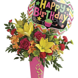 Birthday bouquet with roses, lilies, and a birthday balloon in a pink vase