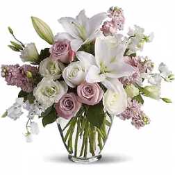 Bouquet of white lilies and pink roses in a clear glass vase