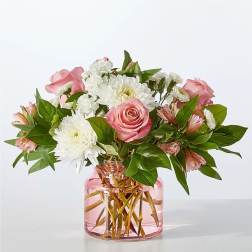 Pink roses and white daisies in a pink glass vase