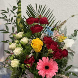Mixed bouquet of red and yellow roses with a pink gerbera daisy in a black box